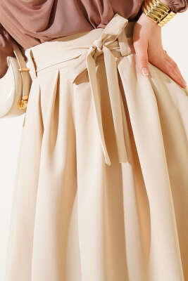 Pileli Kuşaklı Kloş Etek Bej - Uzun Etek